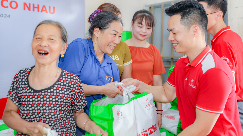 Bà con vui mừng nhận túi hỗ trợ của chương trình