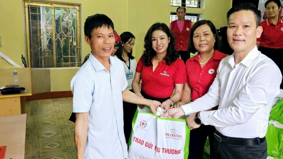 Bà con vui mừng nhận túi hỗ trợ của chương trình